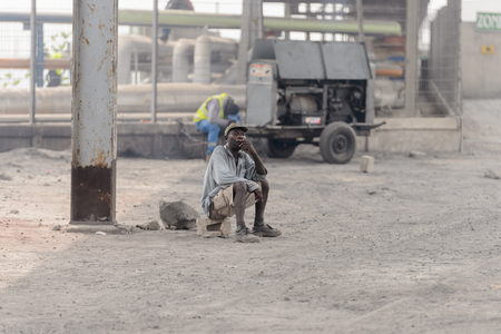 LOME, TOGO - Jan 9, 2017: Unidentified Togolese old man sits on brick. Togo people suffer of poverty due to the bad economyのeditorial素材