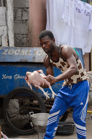 ACCRA, GHANA - Jan 8, 2017: Unidentified Ghanaian man holds a chiken in his hands at the local market. People of Ghana suffer of poverty due to the economic situationのeditorial素材