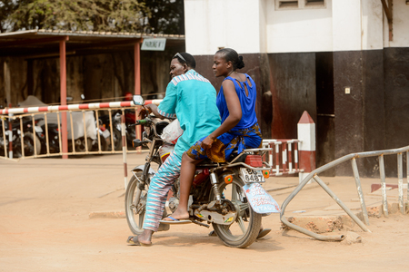 LOME, TOGO - Jan 9, 2017: Unidentified Togolese man and woman ride a motorcycle. Togo people suffer of poverty due to the bad economyのeditorial素材