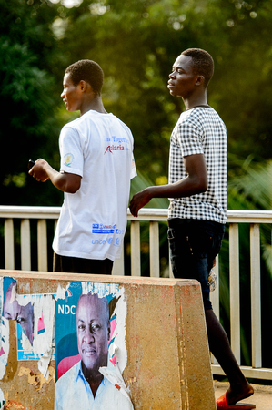 ACCRA, GHANA - Jan 8, 2017: Unidentified Ghanaian boys walk on the street. People of Ghana suffer of poverty due to the economic situationのeditorial素材