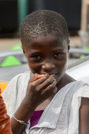ACCRA, GHANA - Jan 8, 2017: Unidentified Ghanaian girl puts her fingers into her mouth at the local market. People of Ghana suffer of poverty due to the economic situationのeditorial素材