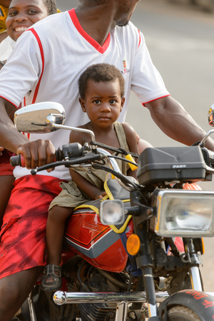 ACCRA, GHANA - Jan 8, 2017: Unidentified Ghanaian man and his family ride a motorcycle on the street. People of Ghana suffer of poverty due to the economic situationのeditorial素材