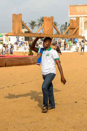OUIDAH, BENIN - Jan 10, 2017: Unidentified Beninese carries a bench on his head at the voodoo festival, which is anually celebrated on January, 10th.のeditorial素材