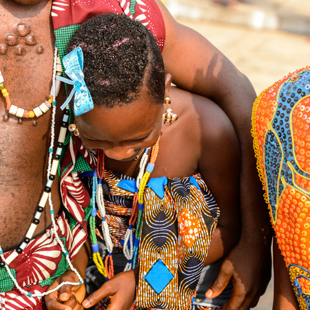 OUIDAH, BENIN - Jan 10, 2017: Unidentified Beninese  little girl in national suit looks down at the voodoo festival, which is anually celebrated on January, 10th.のeditorial素材