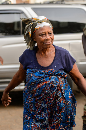 OUIDAH, BENIN - Jan 10, 2017: Unidentified Beninese woman in colored dress and headscarf stands at the voodoo festival, which is anually celebrated on January, 10th.のeditorial素材