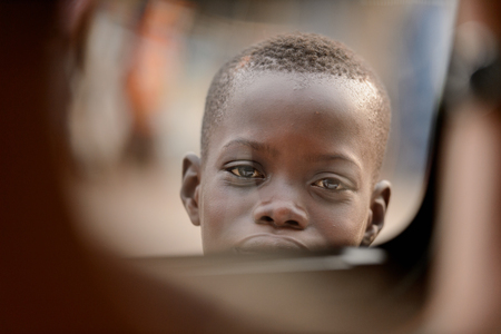 LOME, TOGO - Jan 9, 2017: Unidentified Togolese young boy looks ahead. Togo children suffer of poverty due to the bad economyのeditorial素材