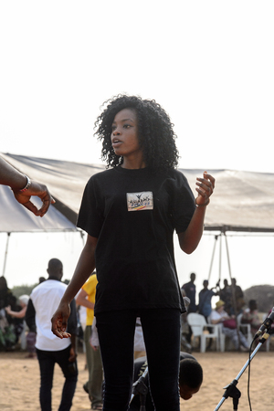 OUIDAH, BENIN - Jan 10, 2017: Unidentified Beninese young girl in black shirt and pants works at the voodoo festival, which is anually celebrated on January, 10th.のeditorial素材