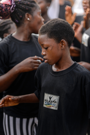 OUIDAH, BENIN - Jan 10, 2017: Unidentified Beninese woman in black shirt looks down at the voodoo...