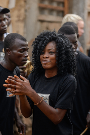 OUIDAH, BENIN - Jan 10, 2017: Unidentified Beninese beautiful curly woman in black shirt smiles at the voodoo festival, which is anually celebrated on January, 10th.のeditorial素材