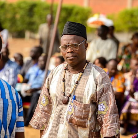 OUIDAH, BENIN - Jan 10, 2017: Unidentified Beninese  old man in national suit wears glasses at the...