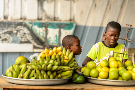 OUIDAH, BENIN - Jan 10, 2017: Unidentified Beninese  little boys sell fruits at the voodoo festival, which is anually celebrated on January, 10th.のeditorial素材