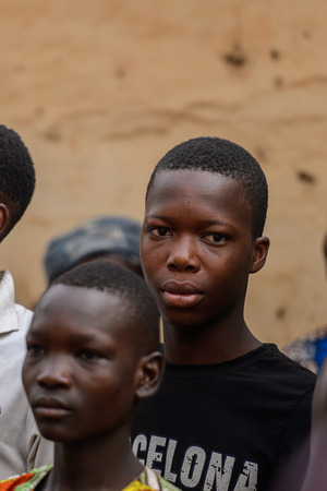 OUIDAH, BENIN - Jan 10, 2017: Unidentified Beninese boy in black shirt looks ahead at the voodoo festival, which is anually celebrated on January, 10th.のeditorial素材