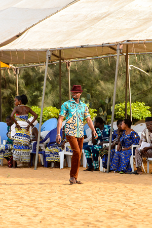 OUIDAH, BENIN - Jan 10, 2017: Unidentified Beninese man in colored clothes wears a hat at the voodoo festival, which is anually celebrated on January, 10th.のeditorial素材