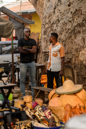 OUIDAH, BENIN - Jan 10, 2017: Unidentified Beninese two men stand near souvenirs for sale at the voodoo festival, which is anually celebrated on January, 10th.のeditorial素材