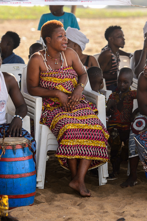OUIDAH, BENIN - Jan 10, 2017: Unidentified Beninese woman in national clothes sit at the voodoo festival, which is anually celebrated on January, 10th.のeditorial素材