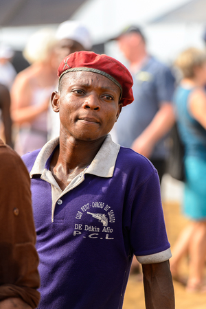 OUIDAH, BENIN - Jan 10, 2017: Unidentified Beninese man in shirt and a cap seriously looks ahead at the voodoo festival, which is anually celebrated on January, 10th.のeditorial素材