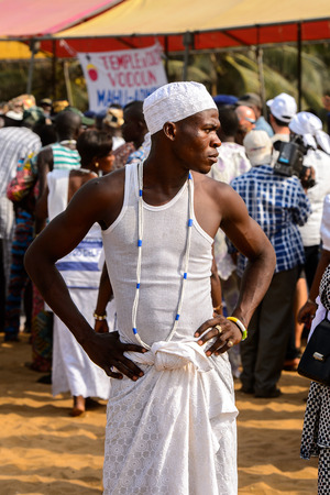 OUIDAH, BENIN - Jan 10, 2017: Unidentified Beninese young boy in white shirt wears necklace at the voodoo festival, which is anually celebrated on January, 10th.のeditorial素材
