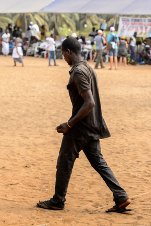 OUIDAH, BENIN - Jan 10, 2017: Unidentified Beninese man in dark clothes from behind at the voodoo festival, which is anually celebrated on January, 10th.のeditorial素材