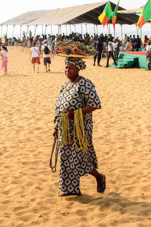 OUIDAH, BENIN - Jan 10, 2017: Unidentified Beninese woman in national clothes carries necklaces n her head at the voodoo festival, which is anually celebrated on January, 10th.のeditorial素材