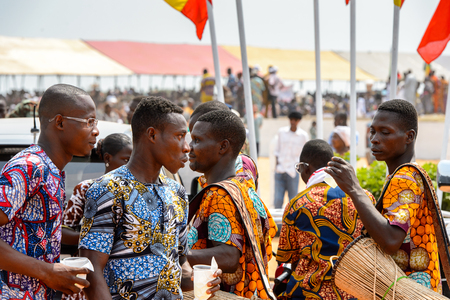 OUIDAH, BENIN - Jan 10, 2017: Unidentified Beninese men in colored suits carry drums at the voodoo festival, which is anually celebrated on January, 10th.のeditorial素材