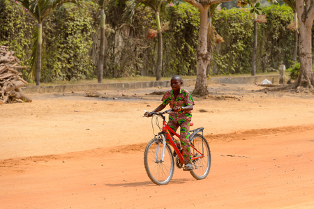 OUIDAH, BENIN - Jan 10, 2017: Unidentified Beninese boy rides a bike on the street in rush hour. It's a popular way of transportationのeditorial素材