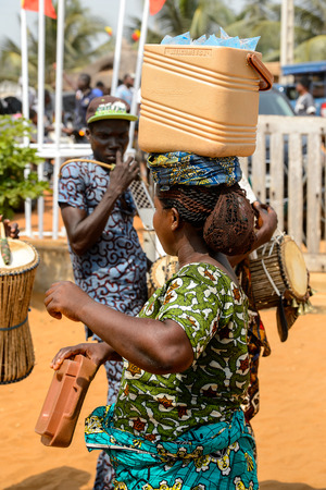 OUIDAH, BENIN - Jan 10, 2017: Unidentified Beninese woman in colored clothes carries a barrel at the voodoo festival, which is anually celebrated on January, 10th.のeditorial素材