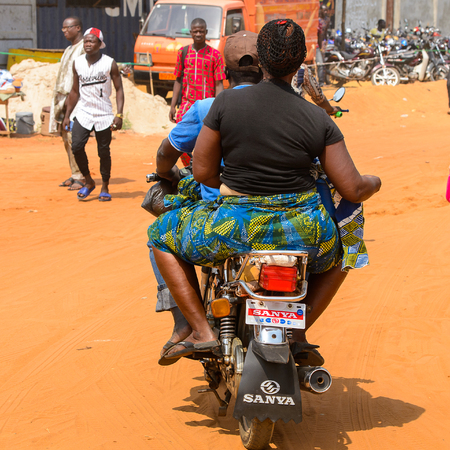 OUIDAH, BENIN - Jan 10, 2017: Unidentified Beninese people ride a motorbike on the street in rush hour from behind.  It's a popular way of transportationのeditorial素材