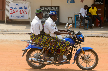 OUIDAH, BENIN - Jan 10, 2017: Unidentified Beninese people ride a motorbike on the street in rush hour. It's a popular way of transportationのeditorial素材
