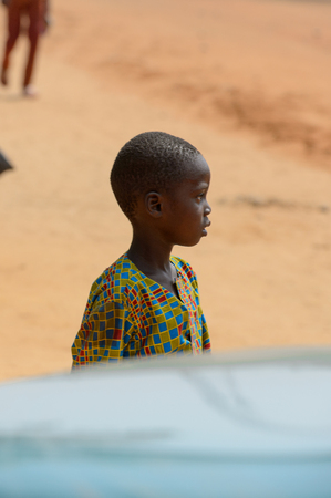 OUIDAH, BENIN - Jan 10, 2017: Unidentified Beninese child in colored suit looks away. Benin children suffer of poverty due to the bad economyのeditorial素材