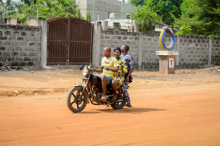 OUIDAH, BENIN - Jan 10, 2017: Unidentified Beninese people ride a motorbike on the street in rush hour. It's a popular way of transportationのeditorial素材