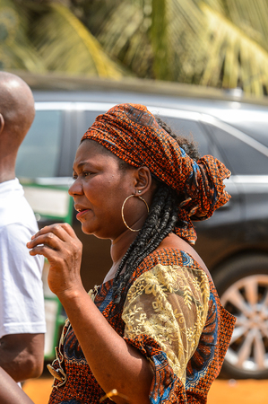 OUIDAH, BENIN - Jan 10, 2017: Unidentified Beninese woman in colored dress and headscarf with braids at the voodoo festival, which is anually celebrated on January, 10th.のeditorial素材