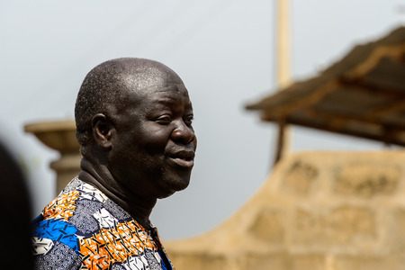 OUIDAH, BENIN - Jan 10, 2017: Unidentified Beninese man in colored shirt tries to say something at the local market. Benin people suffer of poverty due to the bad economyのeditorial素材