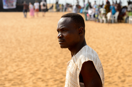 OUIDAH, BENIN - Jan 10, 2017: Unidentified Beninese man in a shirt looks away at the voodoo festival, which is anually celebrated on January, 10th.のeditorial素材