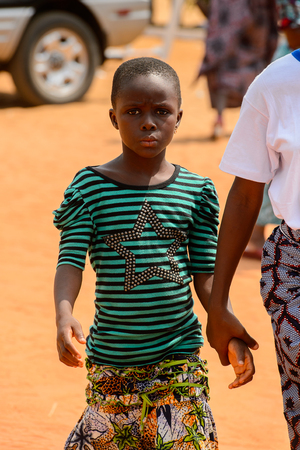 OUIDAH, BENIN - Jan 10, 2017: Unidentified Beninese  little girl is holded by hand at the voodoo festival, which is anually celebrated on January, 10th.のeditorial素材