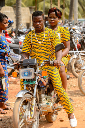 OUIDAH, BENIN - Jan 10, 2017: Unidentified Beninese man rides a motorcycle at the voodoo festival,...