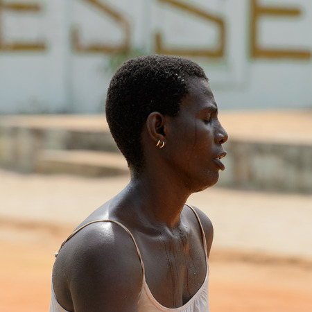 OUIDAH, BENIN - Jan 10, 2017: Unidentified Beninese woman sweats from the heat. Benin people suffer of poverty due to the bad economyのeditorial素材