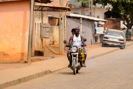 OUIDAH, BENIN - Jan 10, 2017: Unidentified Beninese people ride a motorbike on the street in rush hour. It's a popular way of transportationのeditorial素材