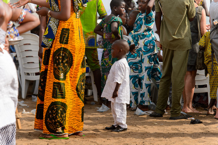 OUIDAH, BENIN - Jan 10, 2017: Unidentified Beninese  little boy in white suit stares at something at the voodoo festival, which is anually celebrated on January, 10th.のeditorial素材