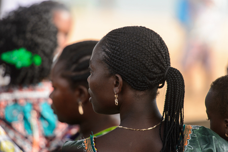 OUIDAH, BENIN - Jan 10, 2017: Unidentified Beninese woman with braids from behind at the voodoo festival, which is anually celebrated on January, 10th.のeditorial素材