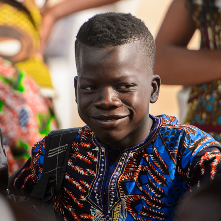 OUIDAH, BENIN - Jan 10, 2017: Unidentified Beninese boy in colored clothes smiles at the voodoo festival, which is anually celebrated on January, 10th.のeditorial素材