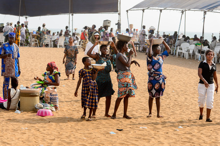 OUIDAH, BENIN - Jan 10, 2017: Unidentified Beninese women carry basins at the voodoo festival, which...