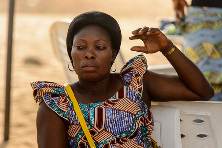 OUIDAH, BENIN - Jan 10, 2017: Unidentified Beninese woman in colored clothes looks away at the voodoo festival, which is anually celebrated on January, 10th.のeditorial素材