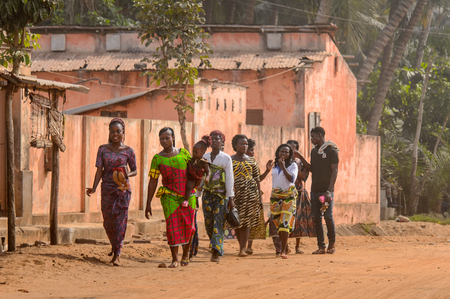 OUIDAH, BENIN - Jan 10, 2017: Unidentified Beninese people in colored clothes walk on the street. Benin people suffer of poverty due to the bad economyのeditorial素材