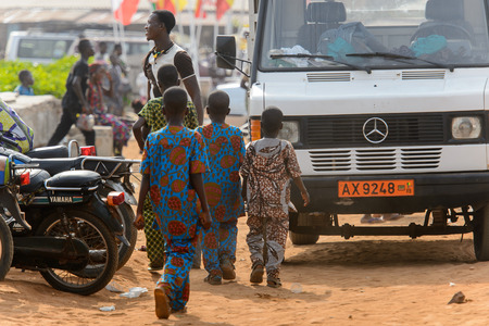 OUIDAH, BENIN - Jan 10, 2017: Unidentified Beninese children in colored suits from behind. Benin children suffer of poverty due to the bad economyのeditorial素材