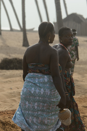 OUIDAH, BENIN - Jan 10, 2017: Unidentified Beninese women in colored dresses from behind. Benin people suffer of poverty due to the bad economyのeditorial素材