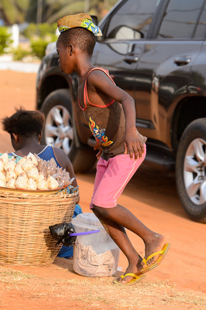 OUIDAH, BENIN - Jan 10, 2017: Unidentified Beninese boy runs around the basket at the  local market. Benin children suffer of poverty due to the bad economyのeditorial素材