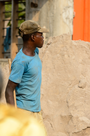 OUIDAH, BENIN - Jan 10, 2017: Unidentified Beninese man looks out for somebody on the street. Benin people suffer of poverty due to the bad economyのeditorial素材