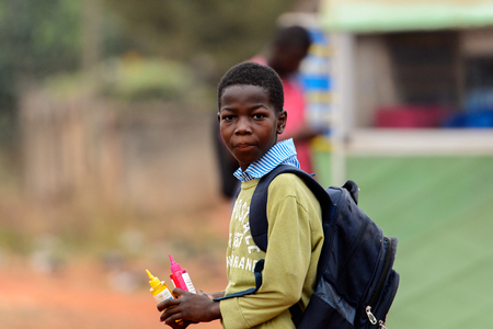 KUMASI, GHANA - Jan 16, 2017: Unidentified Ghanaian little boy with backpack looks around. Children of Ghana suffer of poverty due to the bad economyのeditorial素材
