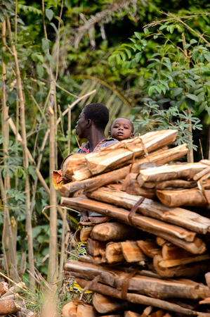 KUMASI, GHANA - Jan 16, 2017: Unidentified Ghanaian woman walks with child on her back. People of...