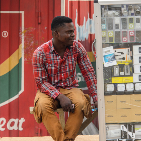 KUMASI, GHANA - Jan 16, 2017: Unidentified Ghanaian man in plaid shirt smiles. People of Ghana suffer of poverty due to the bad economyのeditorial素材